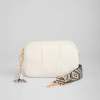 White handbag with a patterned strap on a light gray background