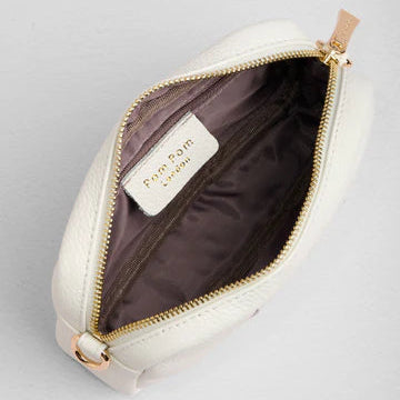 White leather bag with gold zipper on a light gray background