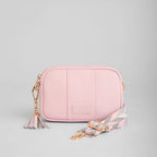 Pink leather bag with a strap on a gray background