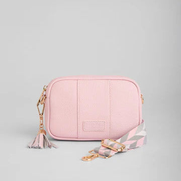Pink leather bag with a strap on a gray background