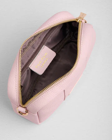 Pink leather bag with gold zipper on a light gray background