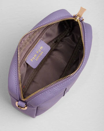 Purple bag with gold zipper on a light gray background