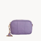 Purple crossbody bag with a tassel on a light gray background