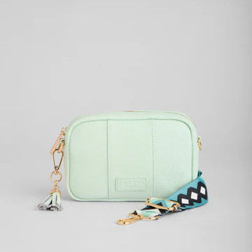 Mint green crossbody bag with a colorful strap on a light gray background