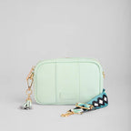 Mint green crossbody bag with a colorful strap on a light gray background