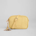 Yellow crossbody bag with a tassel on a light gray background