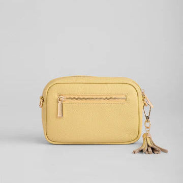 Yellow crossbody bag with a tassel on a light gray background