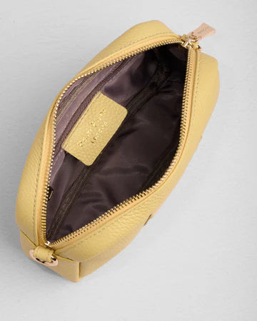 Yellow bag with gold zipper on a light gray background