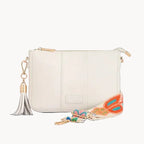 White Pom Pom bag with a colorful strap and tassel on a light gray background