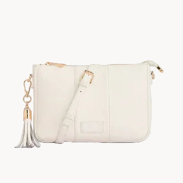 White handbag with gold accents and a tassel on a light gray background