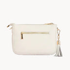 White handbag with gold accents on a light gray background