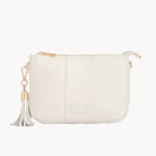 White clutch bag with a gold chain and tassel on a gray background