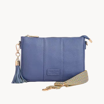 Blue handbag with a tassel on a light gray background