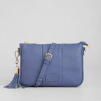 Blue handbag with a tassel on a light gray background