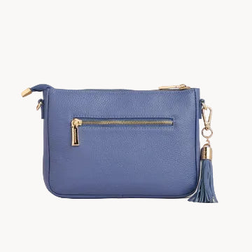 Blue handbag with gold zipper and tassel on a light gray background