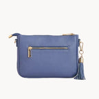 Blue handbag with gold zipper and tassel on a light gray background