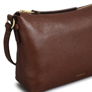 Brown leather handbag with a visible brand logo on a white background