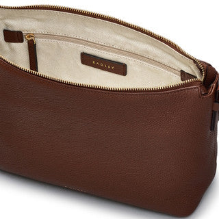 Brown leather bag with a visible brand label on a white background