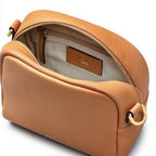 Tan leather handbag with gold zipper on a white background