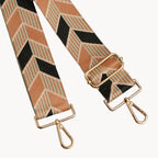 Plaid bag strap with gold hardware on a light gray background