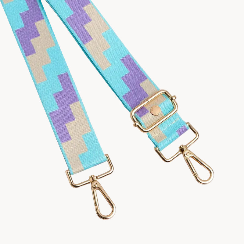 Patterned strap with gold hardware on a light gray background
