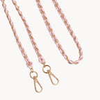 Pink braided bag strap with gold hardware on a light gray background