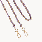 Purple and gold braided bag strap on a light gray background