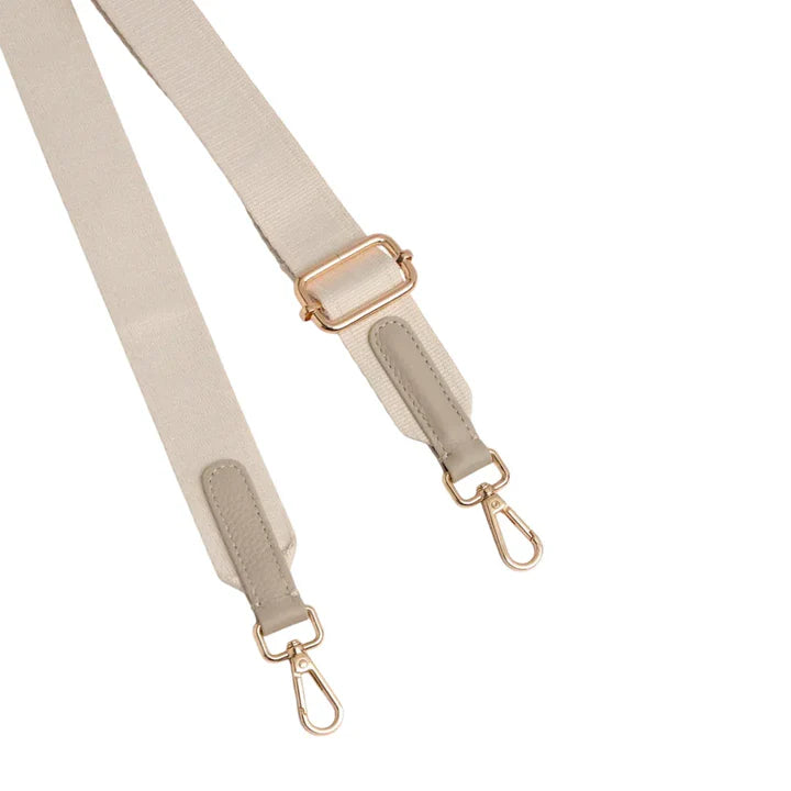 Beige bag strap with gold hardware on a white background