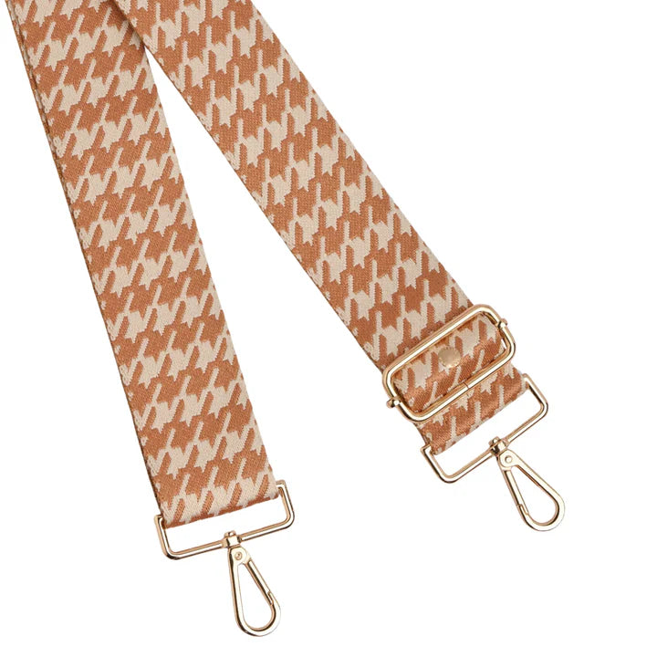 Houndstooth patterned strap with gold hardware on a white background