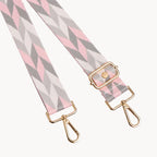 Fabric strap with pink and gray chevron pattern and gold hardware on a light gray background