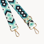 Patterned strap with gold hardware on a light gray background