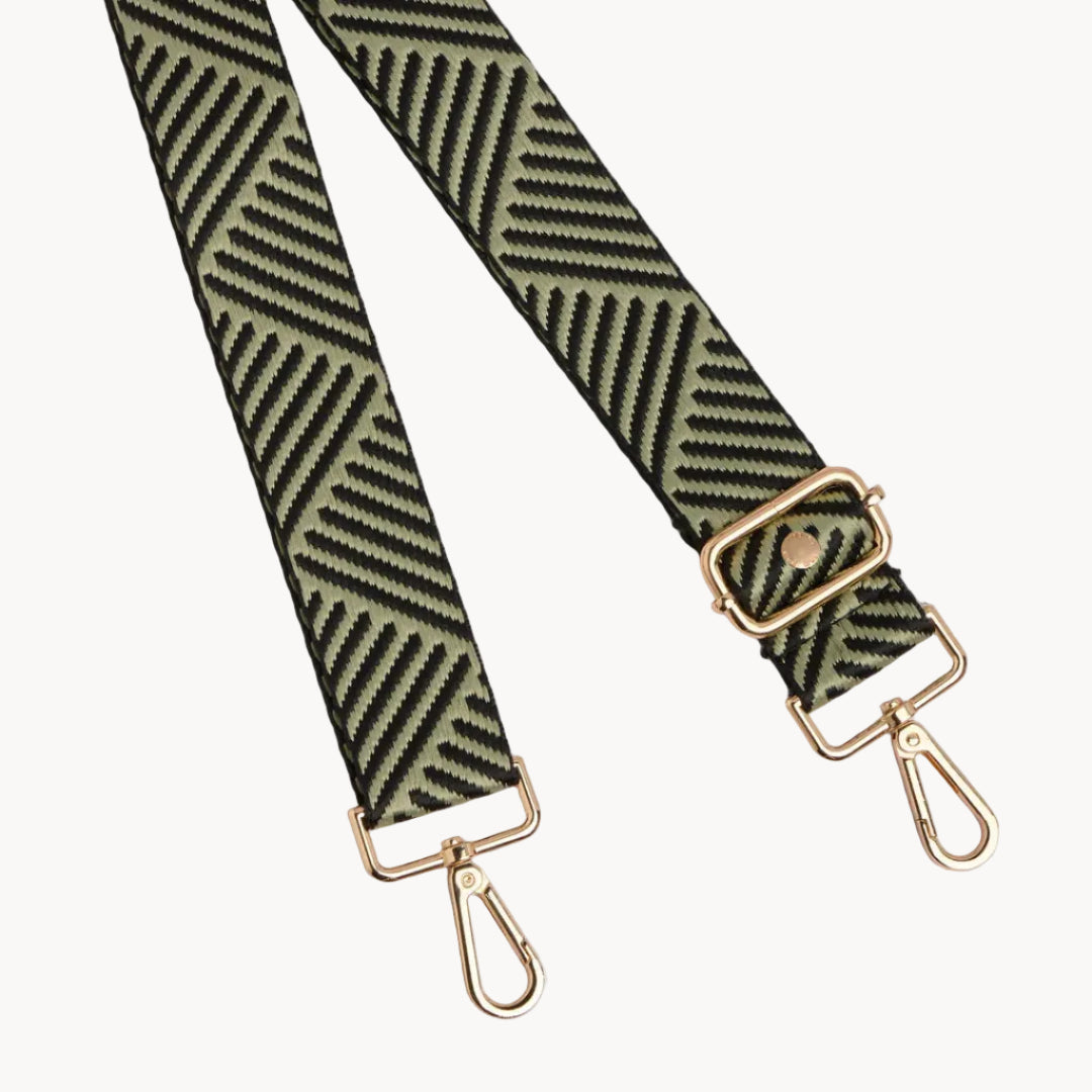 Patterned strap with gold hardware on a gray background