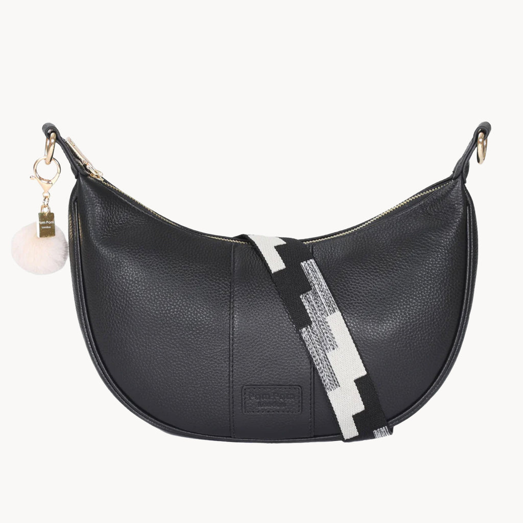 Black handbag with a decorative strap on a white background