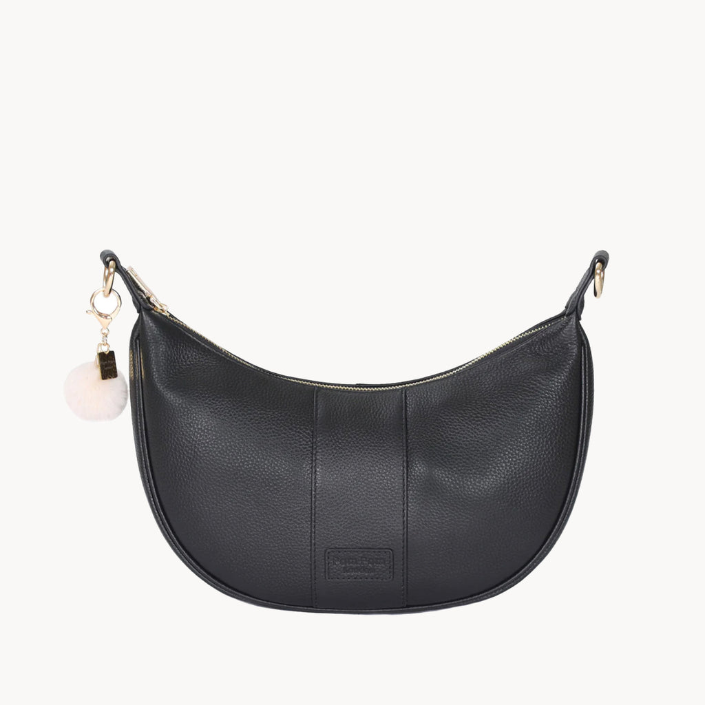 Black handbag with a small white ball charm on a white background
