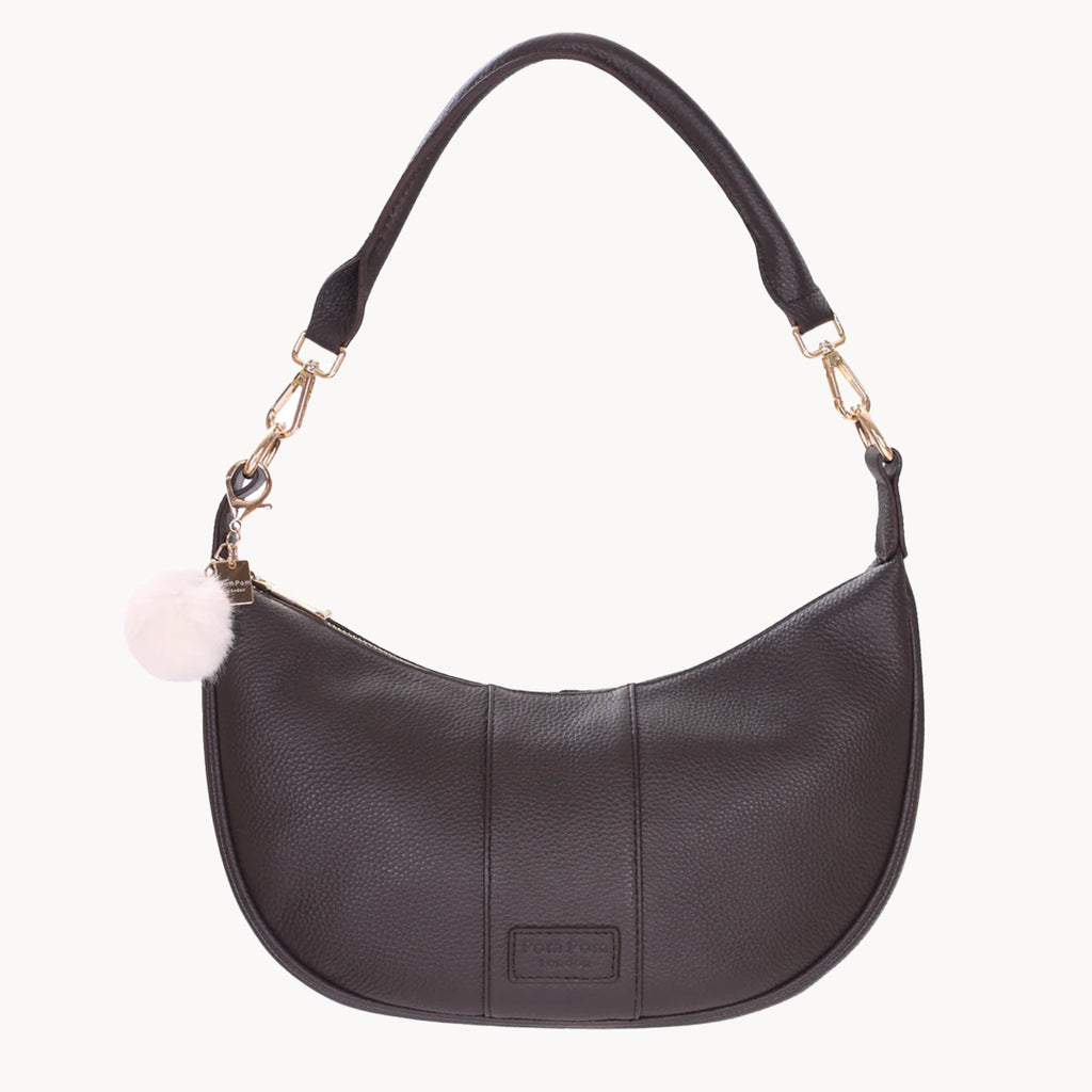 Brown handbag with a pink pom-pom charm on a white background