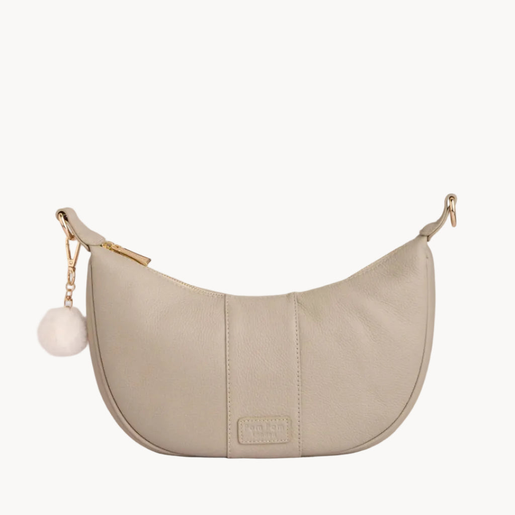Stone handbag with a gold chain and white pom-pom on a light gray background