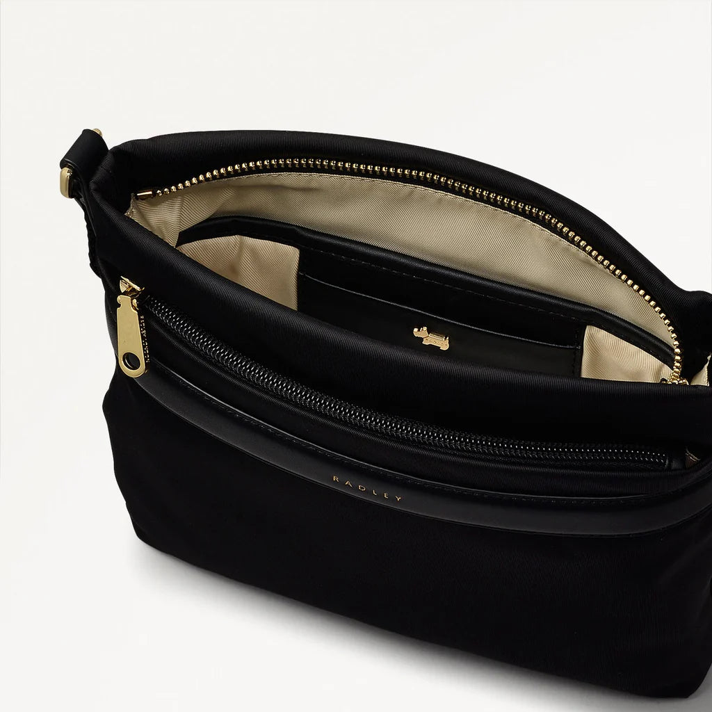 Black handbag with gold zipper and 'Bodil' branding on a light gray background