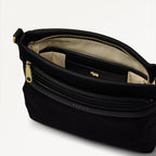 Black handbag with gold zipper and 'Bodil' branding on a light gray background