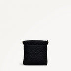 Black quilted handbag on a light beige background