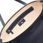 Close-up of a navy blue leather bag with a gold zipper and visible brand name.