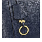 Navy leather bag with a gold tag featuring a dog design on a white background