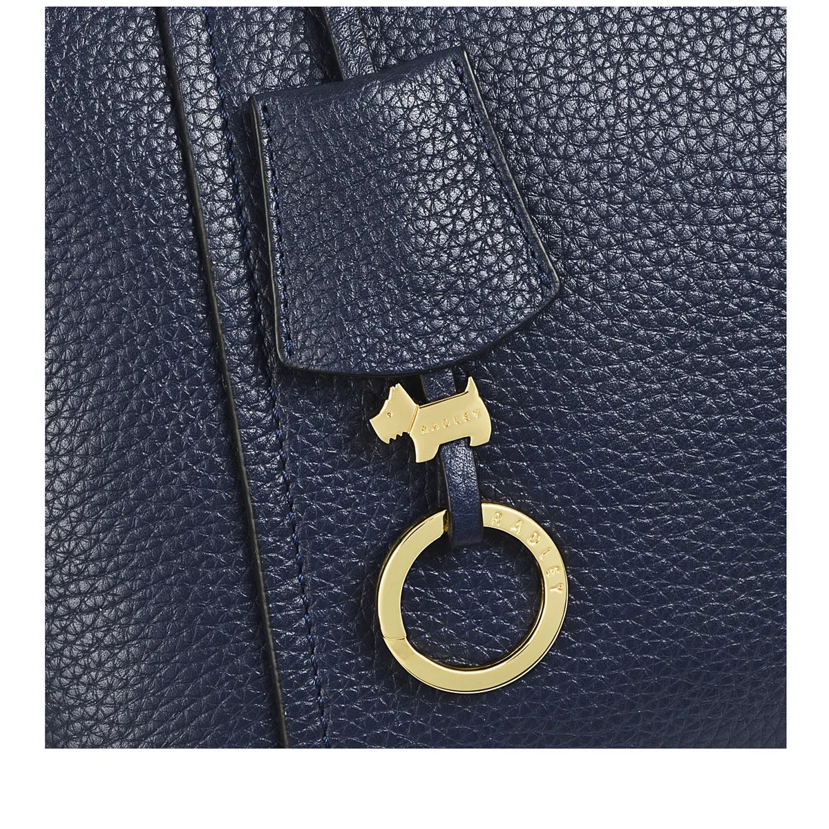 Navy leather bag with a gold tag featuring a dog design on a white background