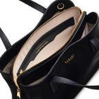 Black handbag with gold zipper and visible brand name on a white background